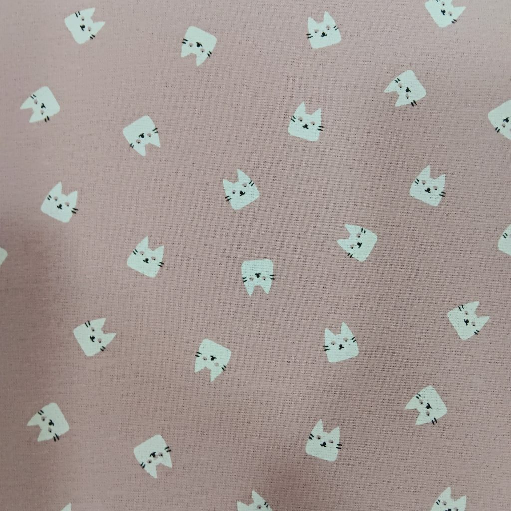 Tela de franela de algodón en un delicado tono rosa con estampado de gatitos. Es perfecta para darle un toque suave, cálido y lleno de ternura a tus proyectos de costura.