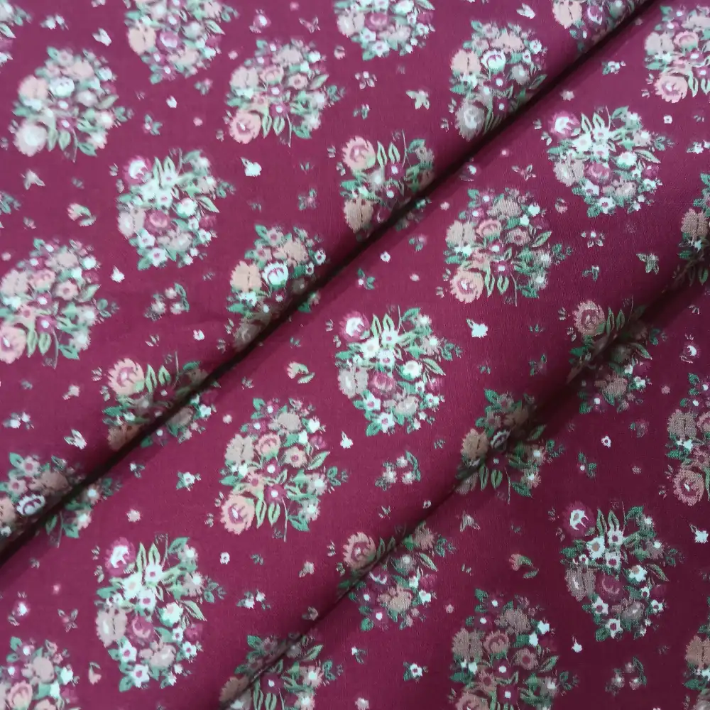 Proyecto nuevo (2) Tela de algodón color granate con estampado de ramos de flores en tonos beige, rosa y verde.