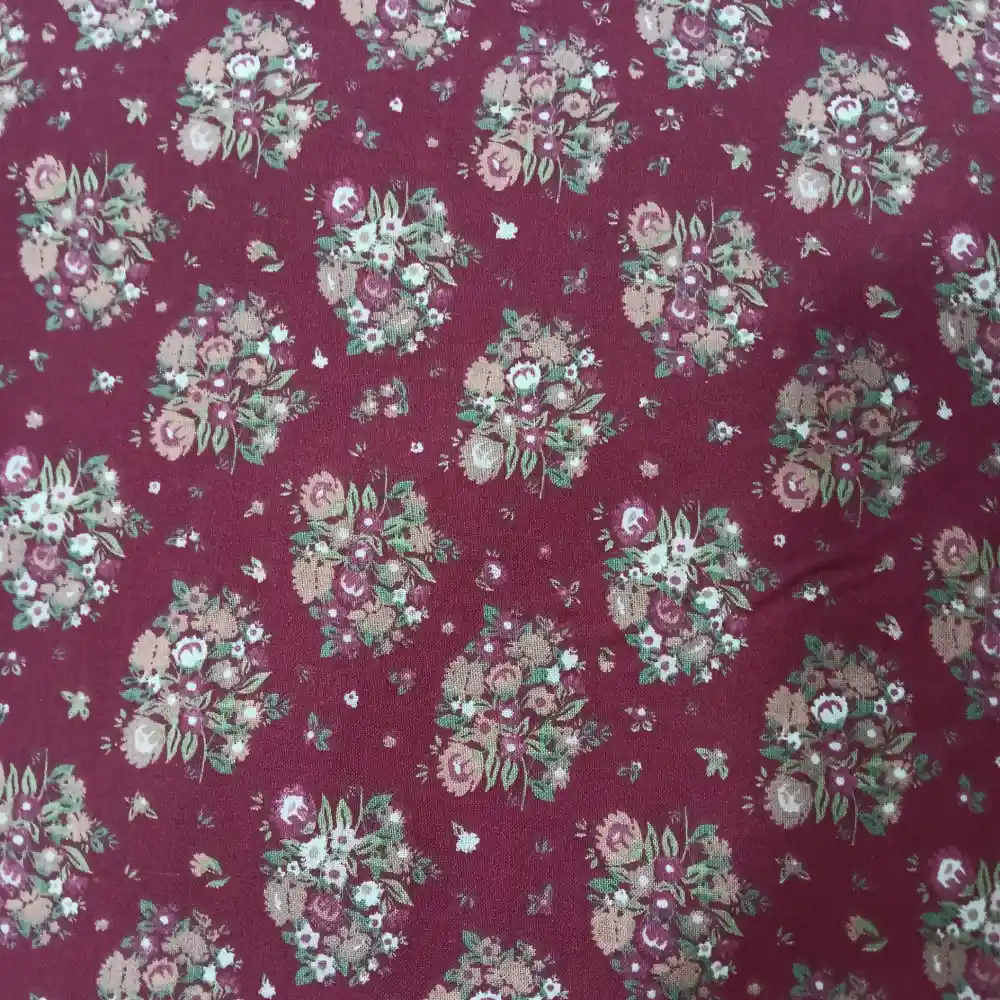 algodon-flores-fondo-granate-1 Tela de algodón color granate con estampado de ramos de flores en tonos beige, rosa y verde.