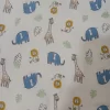 Franela suave para bebé con estampado de jirafas, elefantes y leones sobre fondo beige.