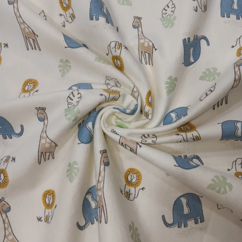 Franela suave para bebé con estampado de jirafas, elefantes y leones sobre fondo beige.