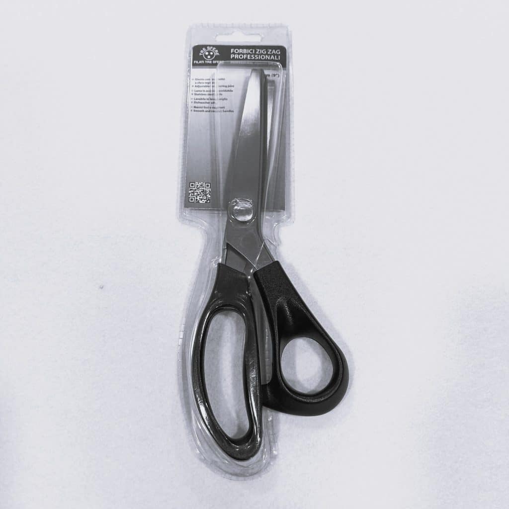 Tijera dentada de costura con mango ergonómico, ideal para cortar telas y evitar que se deshilachen.