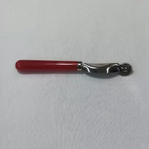 "Rueda de marcar para costura con mango rojo y cabeza metálica dentada, herramienta de sastrería utilizada para transferir patrones sobre tela."