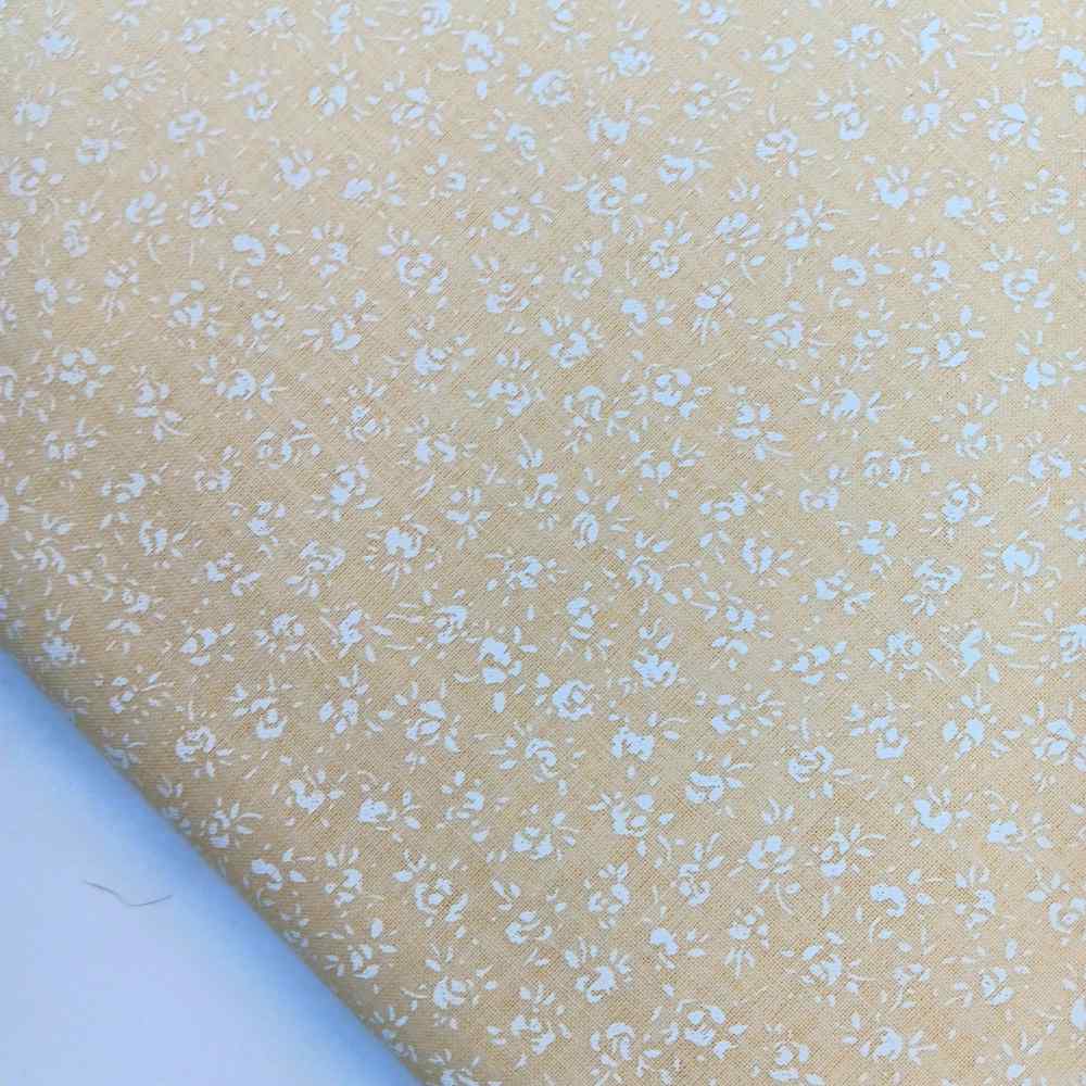 algodon-florecitas-blancas-sobre-algogon-beige Tela de algodón beige con estampado de pequeñas flores blancas, ideal para costura y manualidades