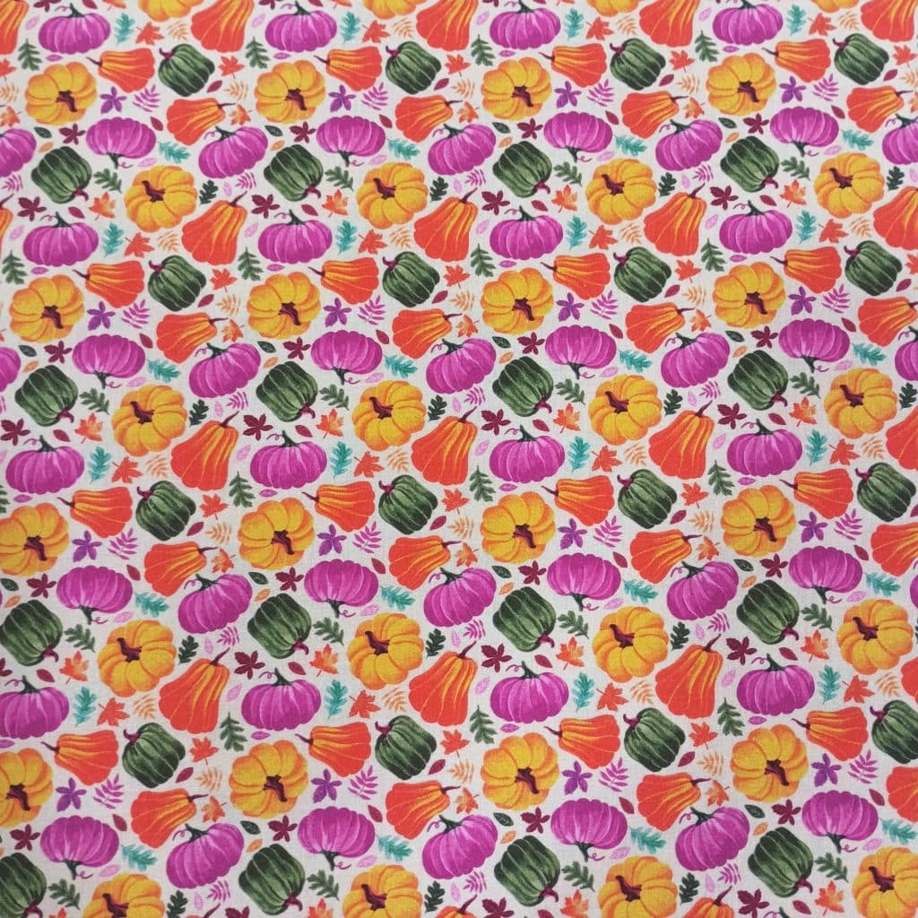 Algodón fondo crudo con estampados de calabazas de halloween en colores otoñales.