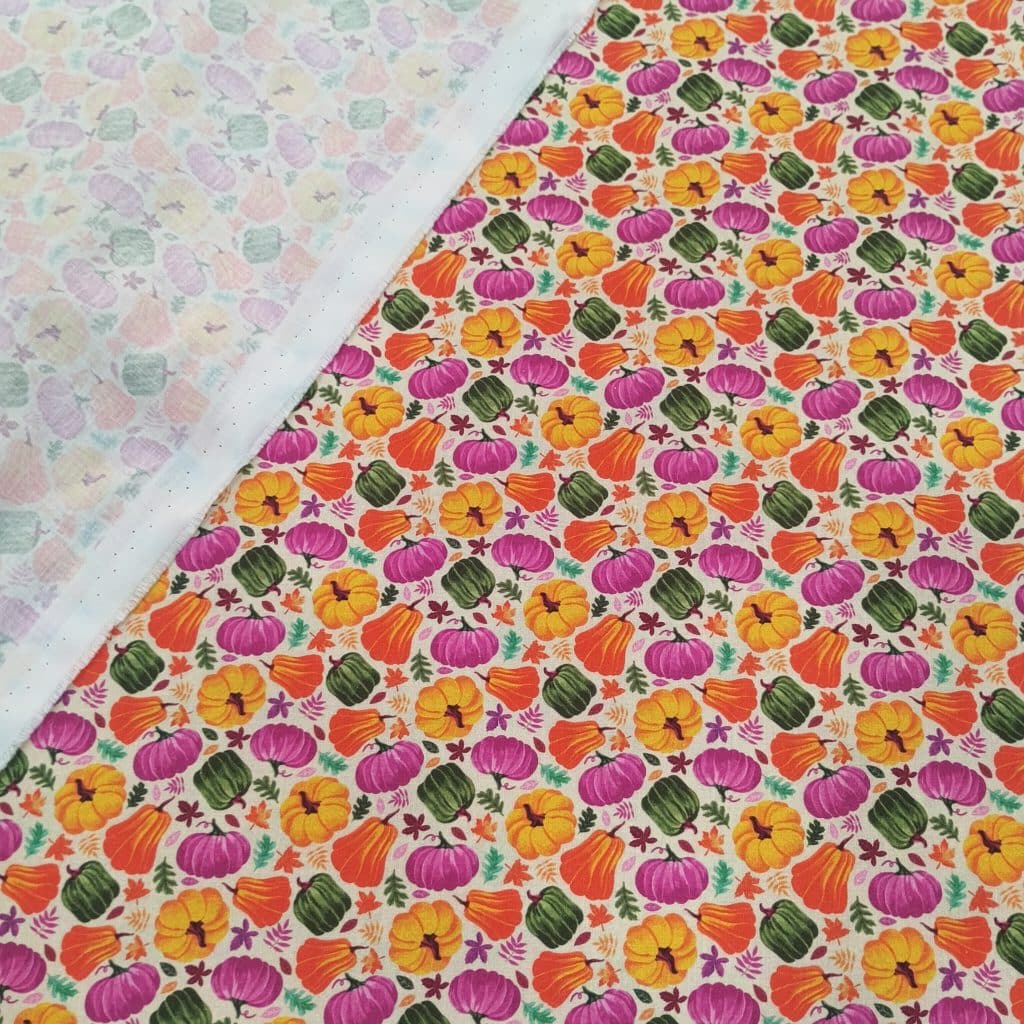 Algodón fondo crudo con estampados de calabazas de halloween en colores otoñales.