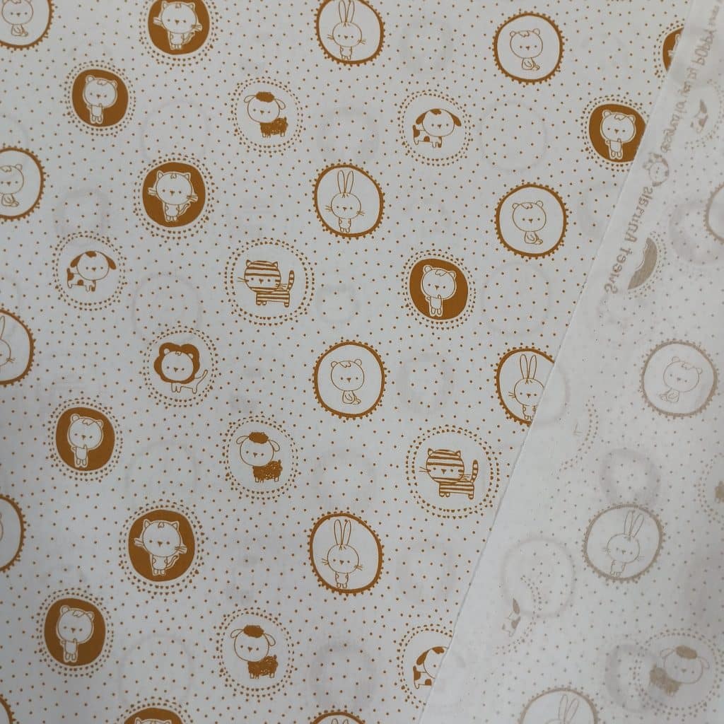 Algodón 100% en blanco con estampado de animalitos enmarcados en ocre y topitos del mismo color