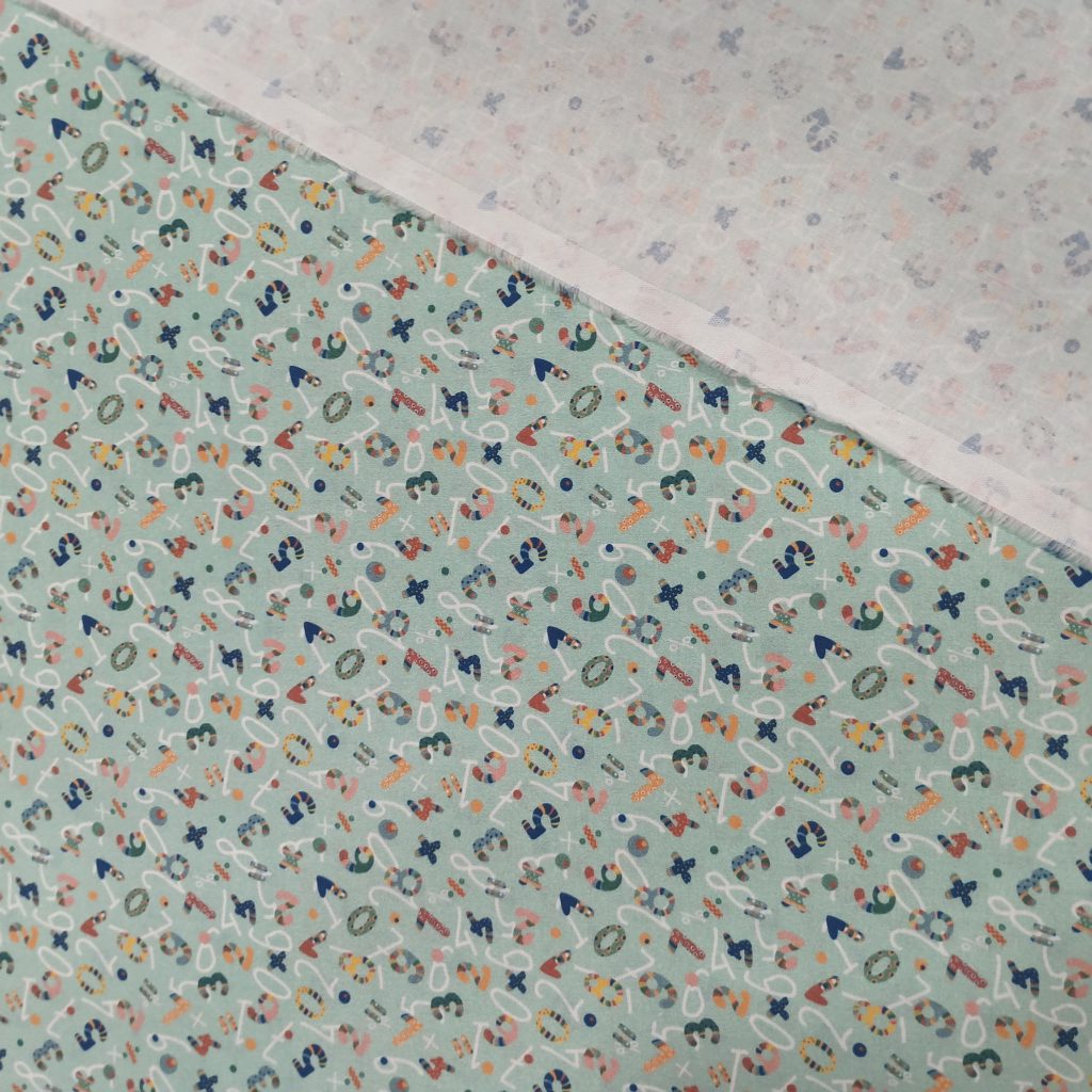 Algodón 100% en fondo verde clarito hay estampados unos divertidos numeros y signos matematicos