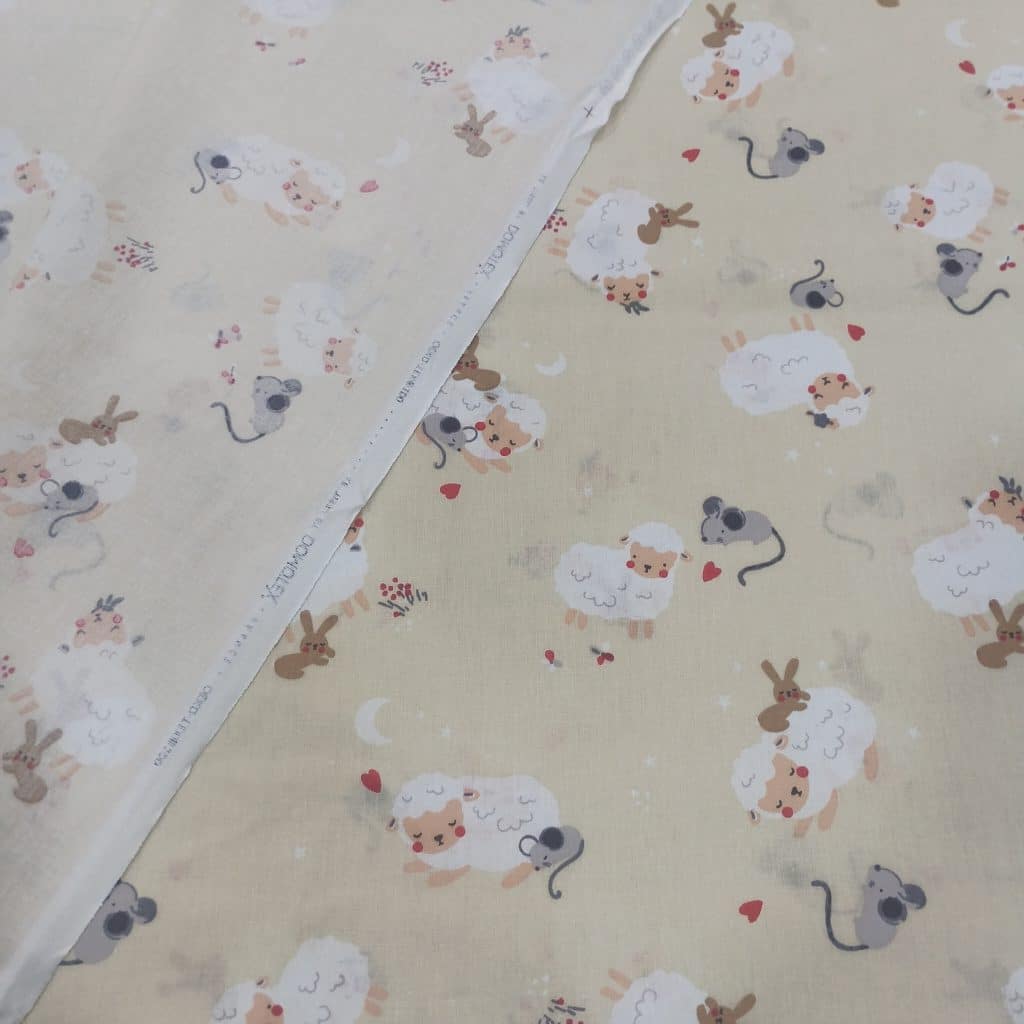 Algodón 100% sobre fondo beig estampadas encontramos unas ovejitas juguetonas divirtiendose con sus amigos los ratoncitos.