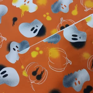 Tela de algodón Halloween naranja con calaveras, calabazas y fantasmas ideal para decoración y costura creativa.