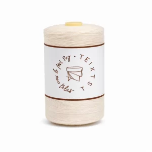 Hilo de hilvanar color crudo con etiqueta Teixits Las Mil y Una Telas