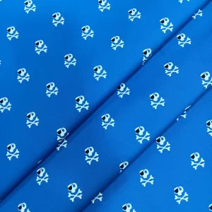 Tela de algodón estampada azul con calaveras blancas, ideal para confección, decoración, patchwork y manualidades.