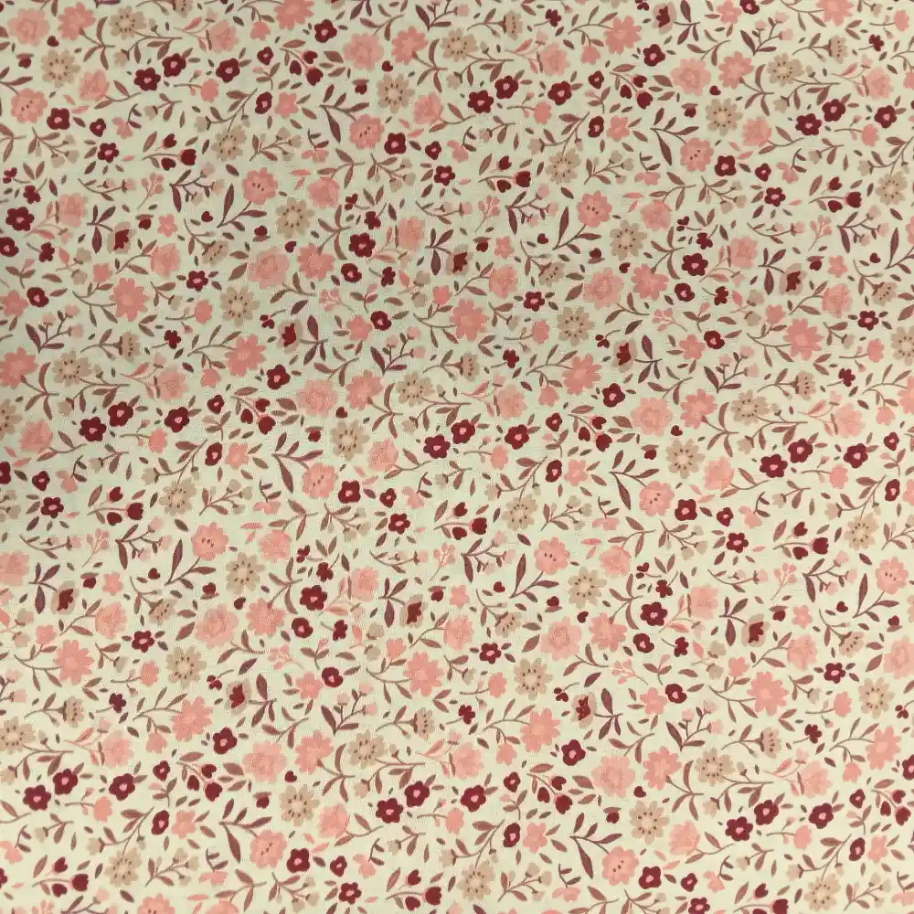Tela de algodón estampada con flores pequeñas rosas sobre fondo claro, ideal para confección, patchwork y decoración del hogar.