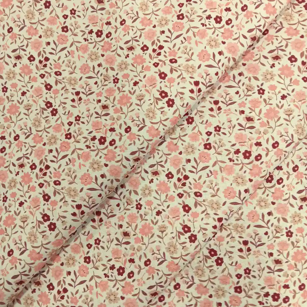Tela de algodón estampada con flores pequeñas rosas sobre fondo claro, ideal para confección, patchwork y decoración del hogar.