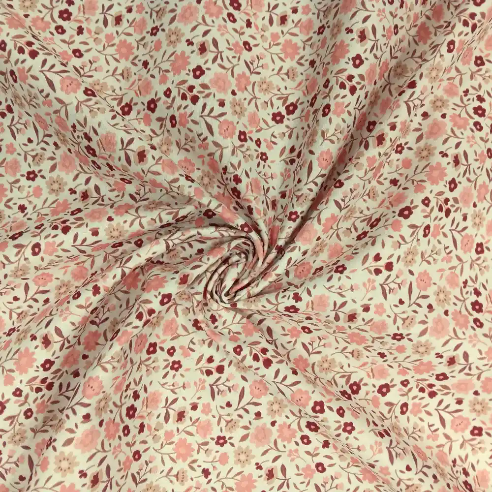 Tela de algodón estampada con flores pequeñas rosas sobre fondo claro, ideal para confección, patchwork y decoración del hogar.