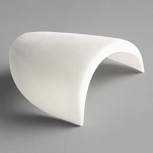 Hombrera forrada blanca con forma curvada, sobre fondo gris y con sombra marcada que resalta su volumen