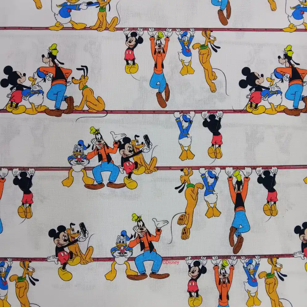 Tela de algodón con licencia Disney, estampado de Mickey Mouse y sus amigos Goofy, Pluto y Donald en fondo claro.