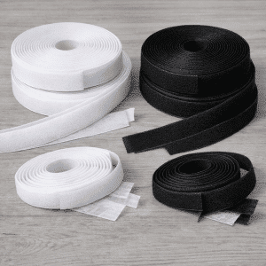 Rollos de velcro autoadhesivo en blanco y negro sobre mesa de madera clara