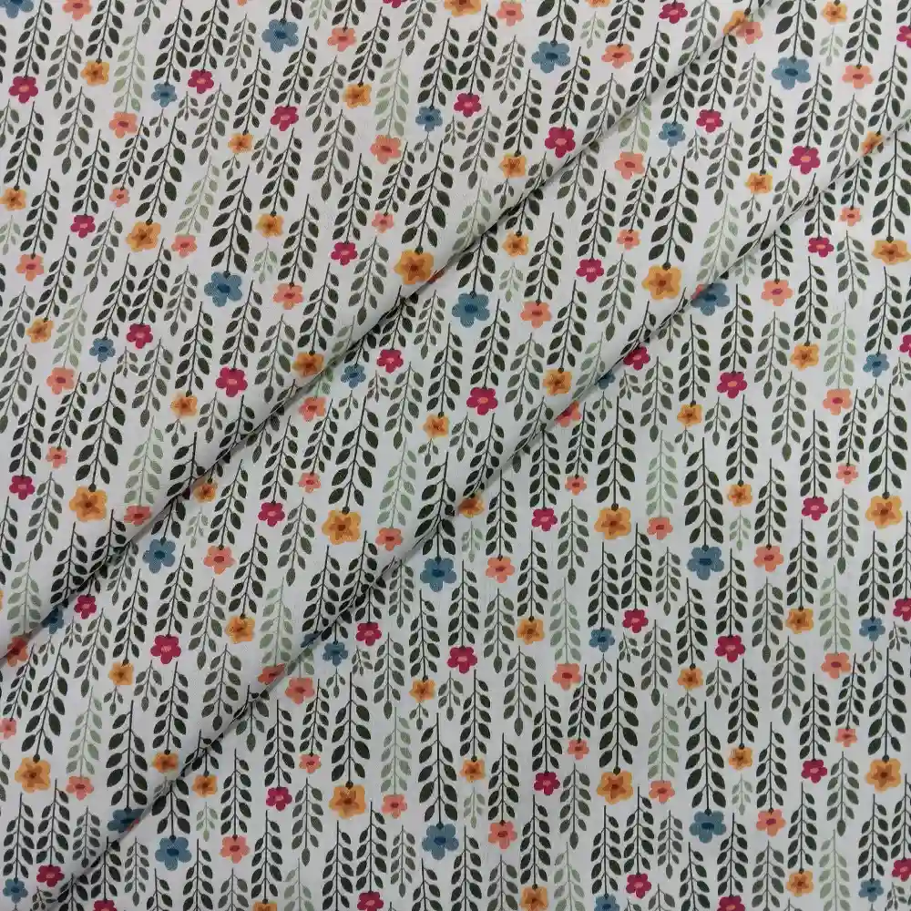 Tela de algodón estampado con flores pequeñas de colores y tallos verdes distribuidos sobre fondo claro, con diseño floral repetido.