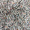 Tela de algodón estampado con flores pequeñas de colores y tallos verdes distribuidos sobre fondo claro, con diseño floral repetido.