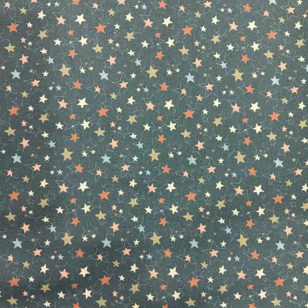 Tela de algodón azul con estampado de estrellas de distintos tamaños en colores suaves, repartidas de forma uniforme sobre el tejido.