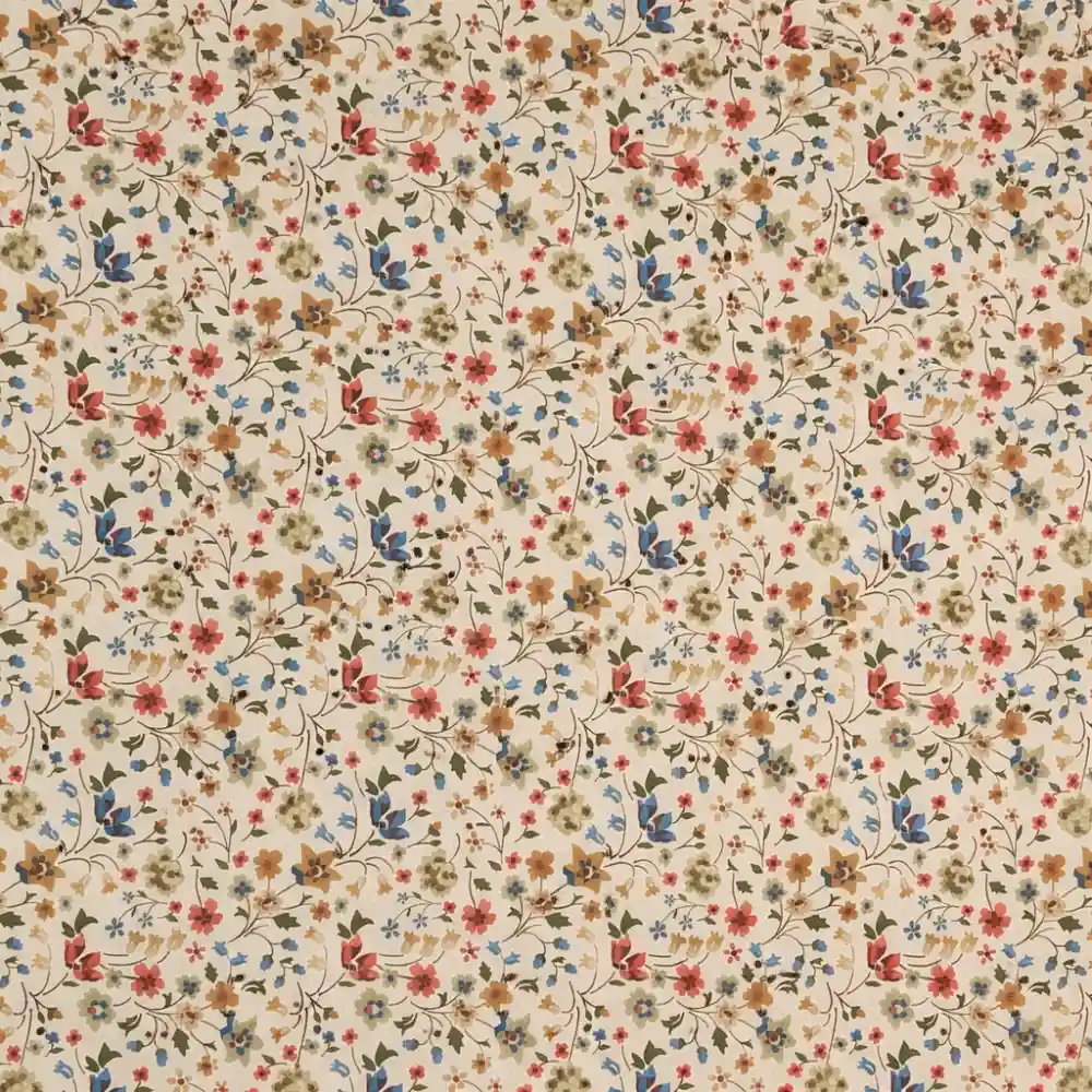 Tela de algodón con estampado floral en tonos verdes, azules y teja sobre fondo beige.