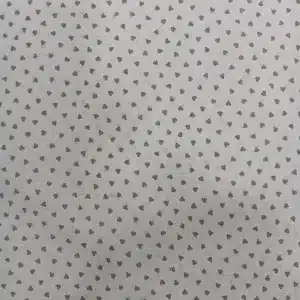 Tela de algodón blanco con estampado de pequeños corazones beige