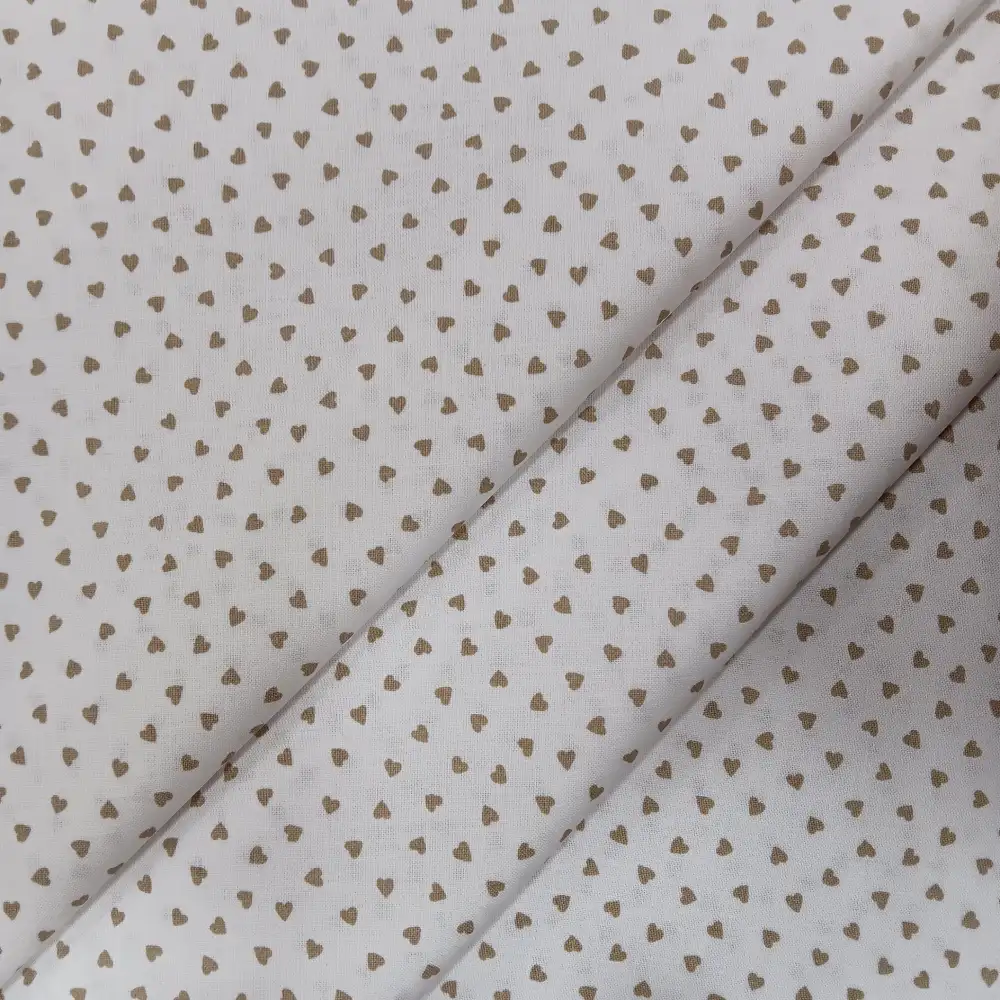 Tela de algodón blanco con estampado de pequeños corazones beige