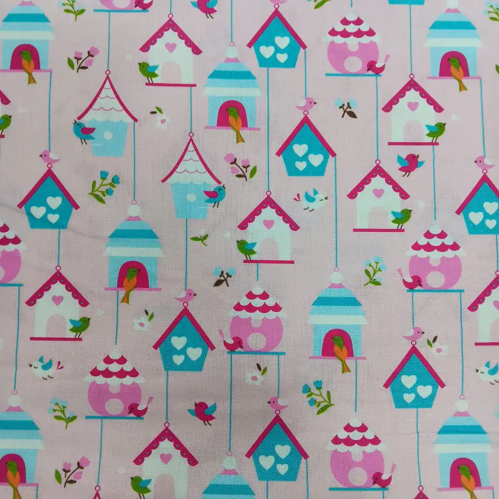 Tela de algodón con estampado infantil de casitas de pájaros y pequeños pájaros de colores sobre fondo rosa.