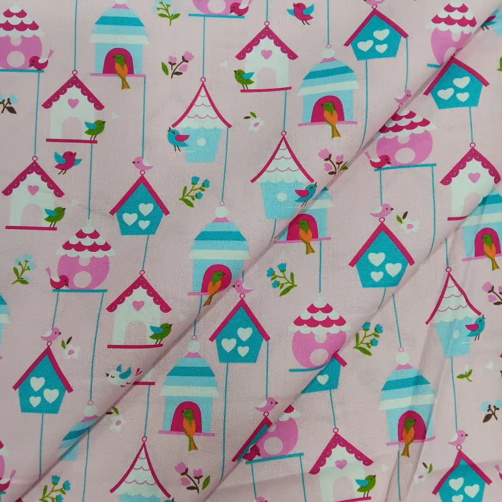 Tela de algodón con estampado infantil de casitas de pájaros y pequeños pájaros de colores sobre fondo rosa.