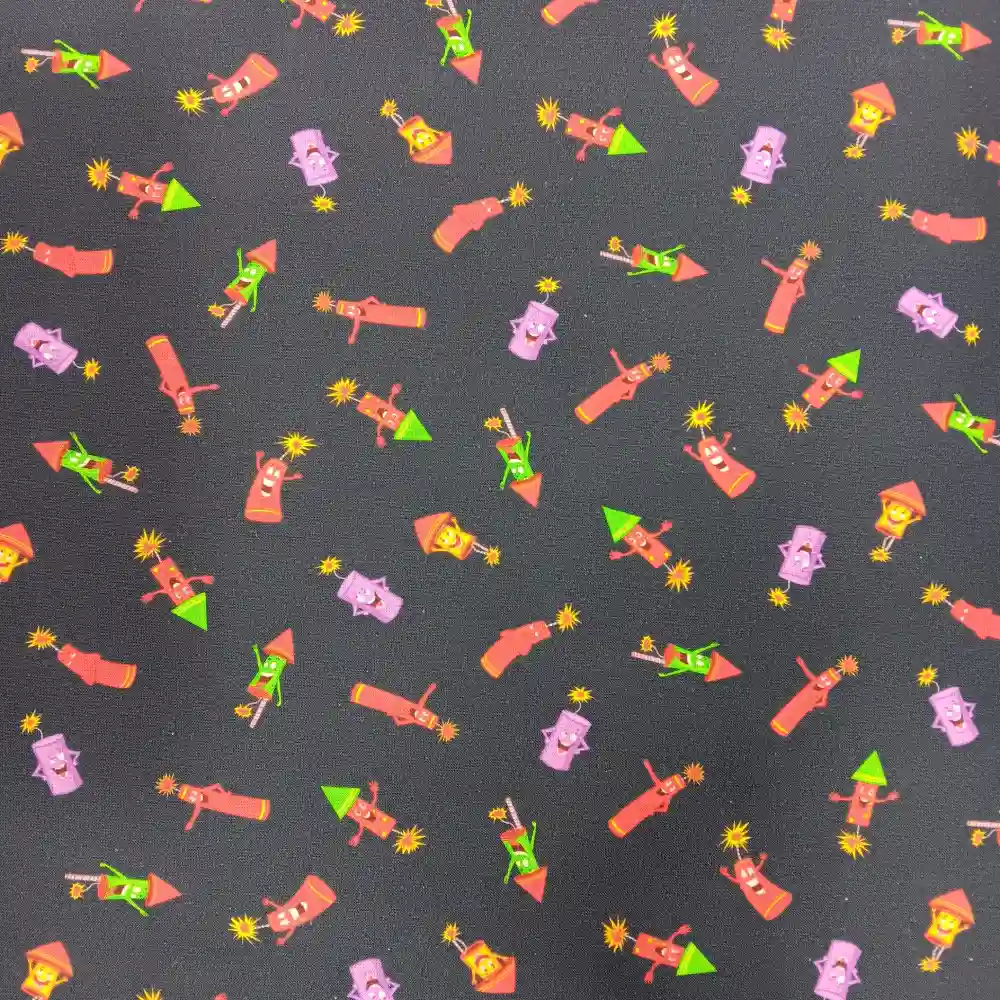 Tela de algodón con fondo oscuro y estampado repetido de pequeños cohetes de colores con caritas sonrientes y detalles de explosiones decorativas.
