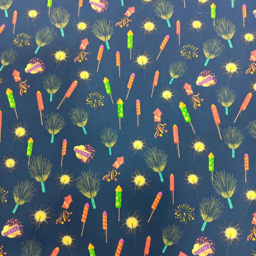 Tela de algodón con estampado de cohetes, petardos y fuegos artificiales de colores sobre fondo azul oscuro.