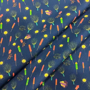 Tela de algodón con estampado de cohetes, petardos y fuegos artificiales de colores sobre fondo azul oscuro.