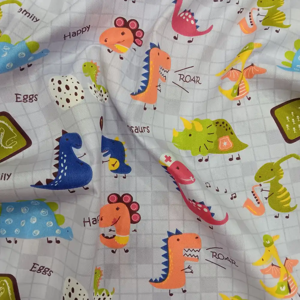 Tela de algodón con estampado infantil de dinosaurios de colores sobre fondo claro con dibujos y palabras decorativas