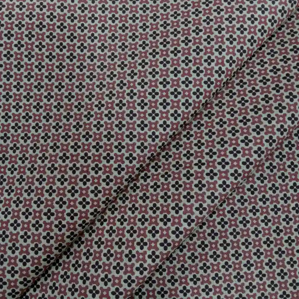 Tela de algodón estampado geométrico de tréboles en tonos suaves.