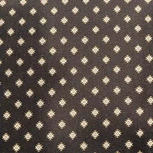 Tela de algodón estampado geométrico tribal con motivos étnicos sobre fondo oscuro.