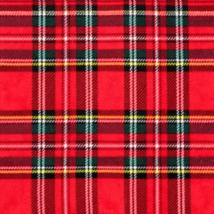 Primer plano de una tela coralina con estampado de cuadros escoceses en rojo, verde, azul y blanco, estilo clásico navideño.