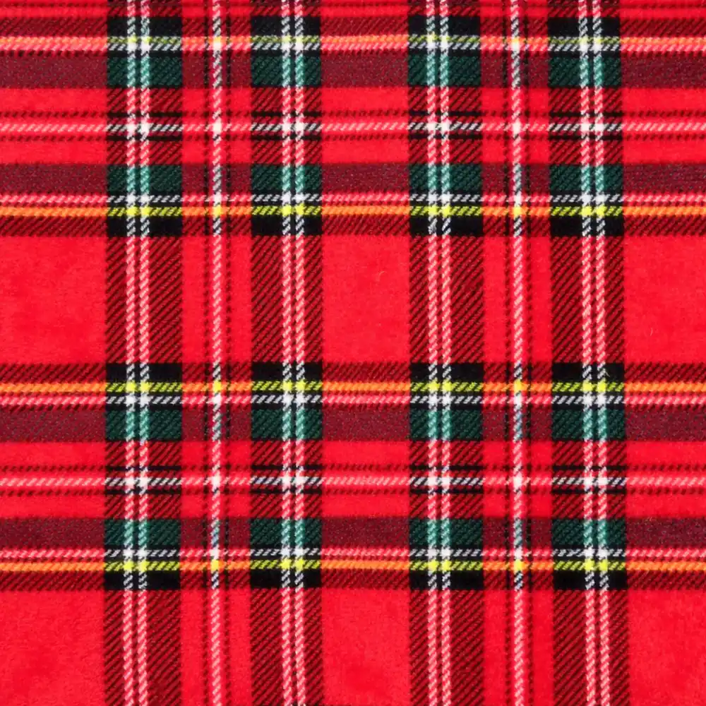 Primer plano de una tela coralina con estampado de cuadros escoceses en rojo, verde, azul y blanco, estilo clásico navideño.