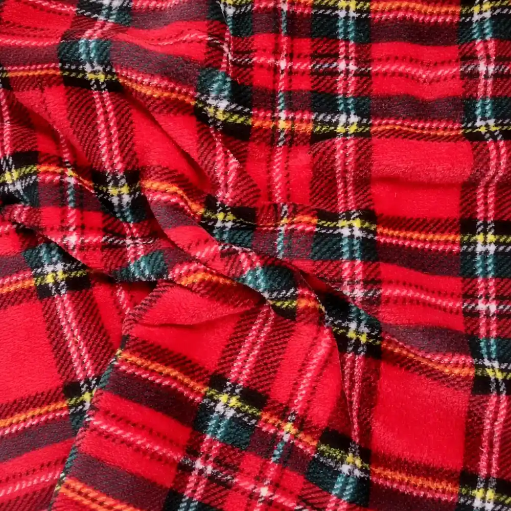 Primer plano de una tela coralina con estampado de cuadros escoceses en rojo, verde, azul y blanco, estilo clásico navideño."