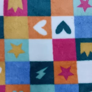 Primer plano de una tela coralina con cuadros multicolor decorados con corazones, estrellas y pequeños símbolos