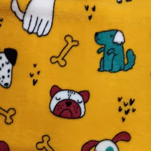 Primer plano de una tela coralina amarilla con dibujos infantiles de perritos, huesos y pequeñas huellas negras