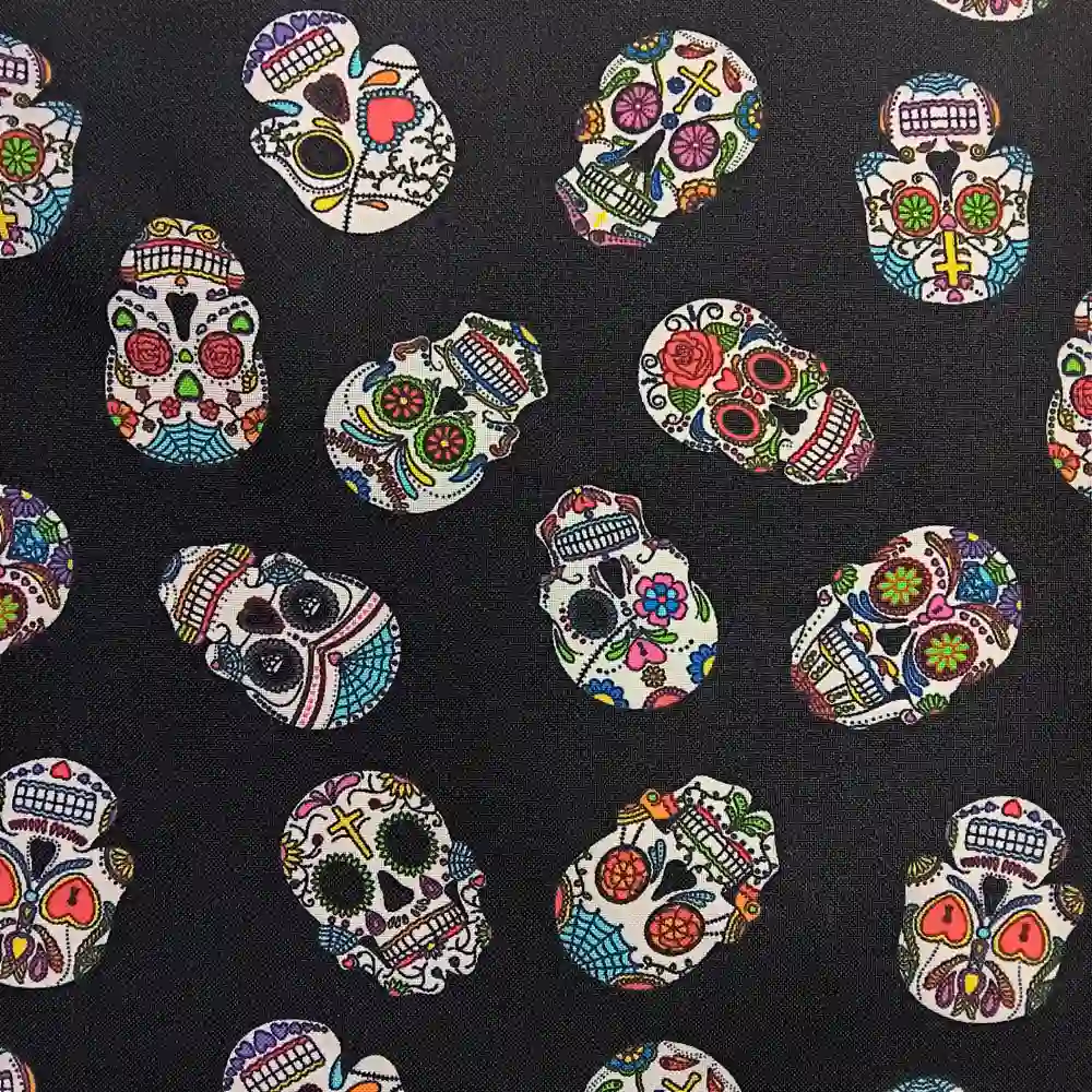 Imagen de una tela de poliéster de fondo negro con un patrón repetido de calaveras mexicanas decoradas con colores vivos como rosa, verde, azul, amarillo y rojo.