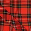 Tela stretch con estampado de cuadro escocés en tonos rojo, negro y amarillo, mostrada en primer plano para apreciar su patrón clásico.