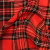 Tela stretch con estampado de cuadro escocés en tonos rojo, negro y amarillo, mostrada en primer plano para apreciar su patrón clásico.