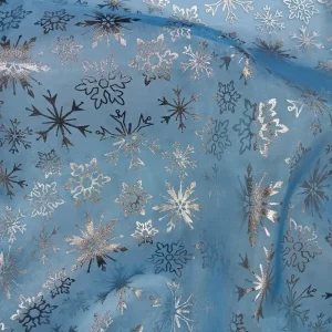 Tela de organza azul con estampado de copos de nieve plateados