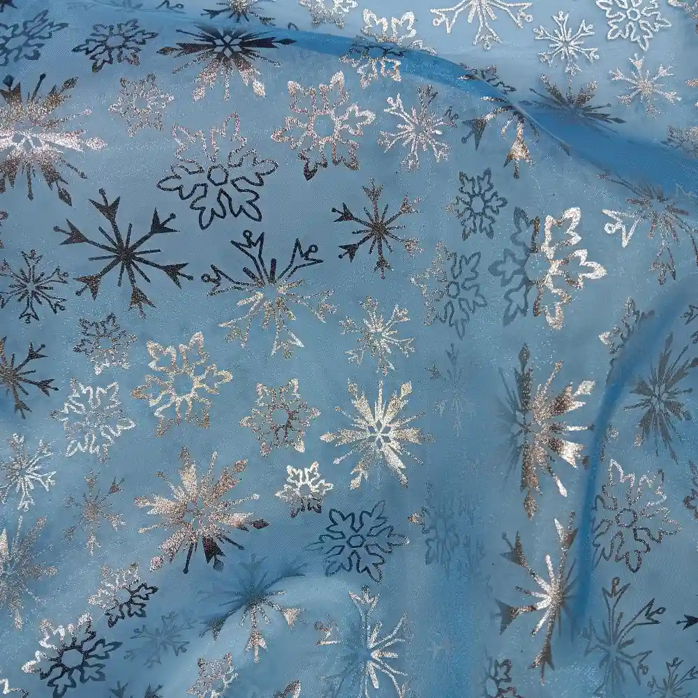 Tela de organza azul con estampado de copos de nieve plateados