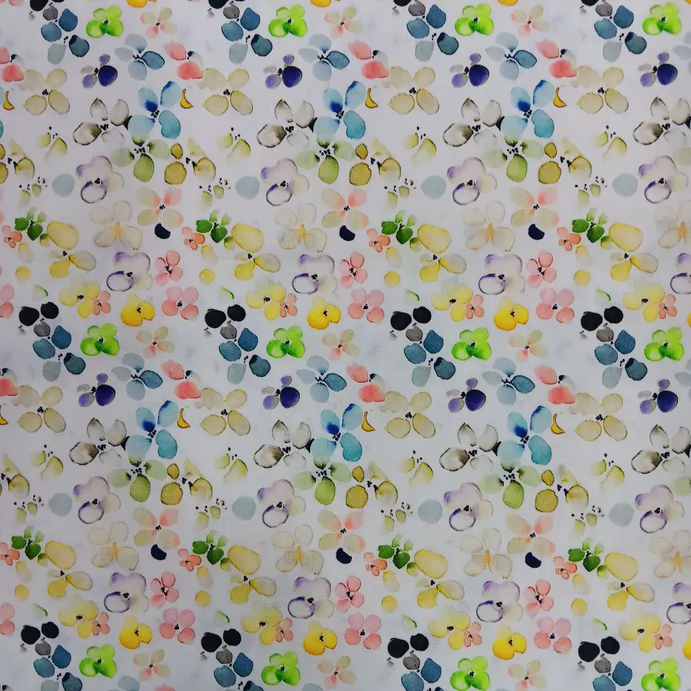 Tela de algodón blanca con estampado floral multicolor estilo acuarela, con pequeñas flores en tonos suaves amarillo, rosa, verde, azul y lila repartidas por toda la superficie.