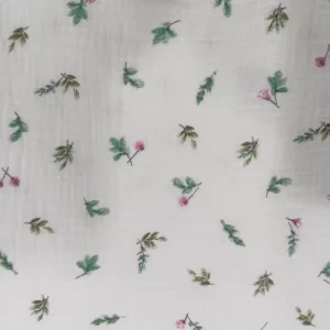 Muselina de algodón estampada con pequeñas flores rosas y hojas verdes sobre fondo claro