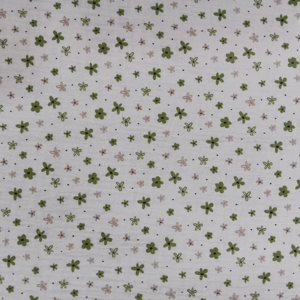 Muselina de algodón estampada con pequeñas flores verdes sobre fondo claro