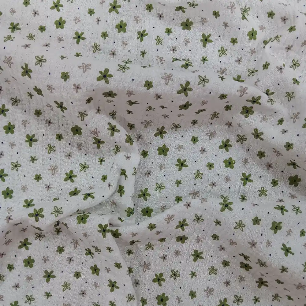 Muselina de algodón estampada con pequeñas flores verdes sobre fondo claro